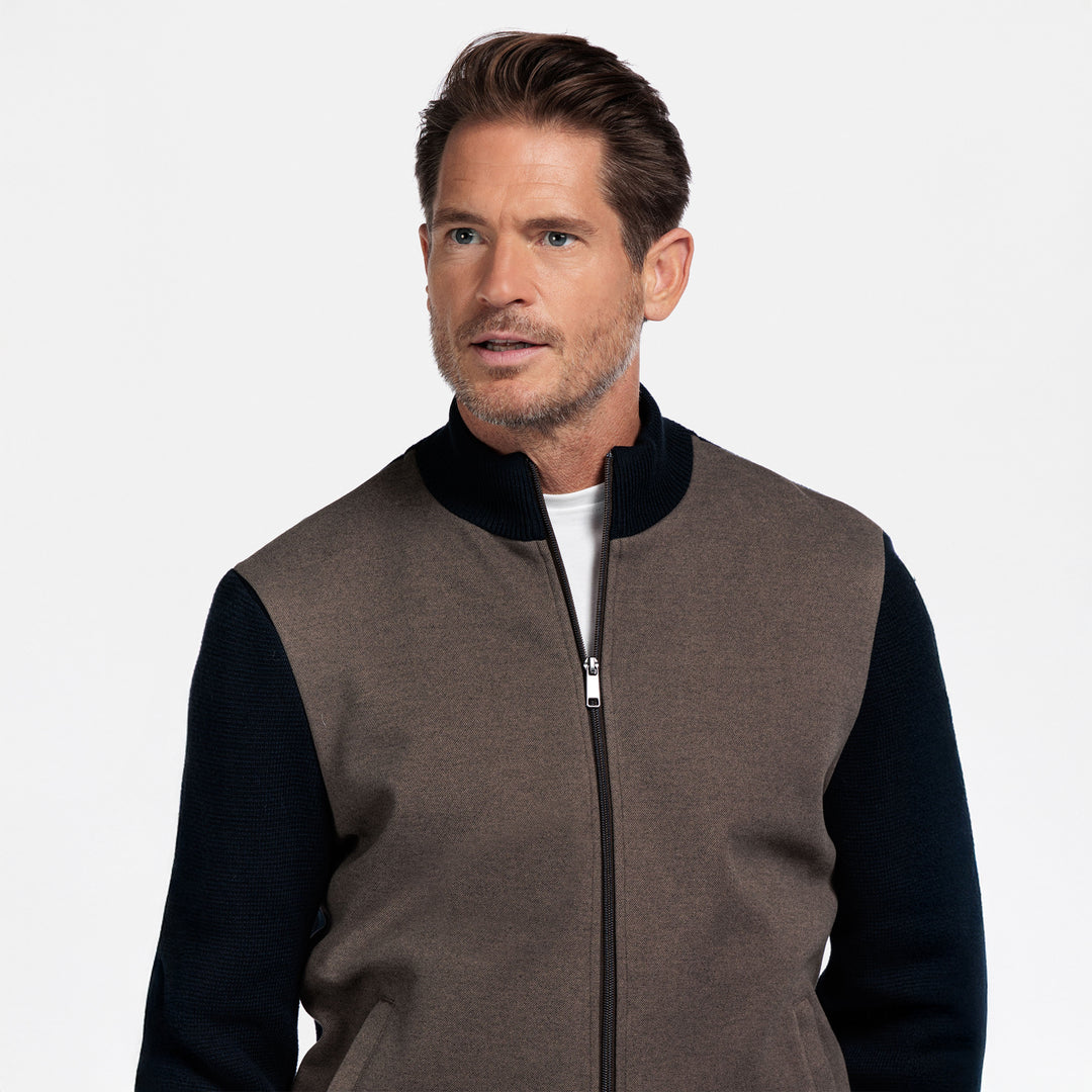 Man wearing a brown and navy cardigan on a white background