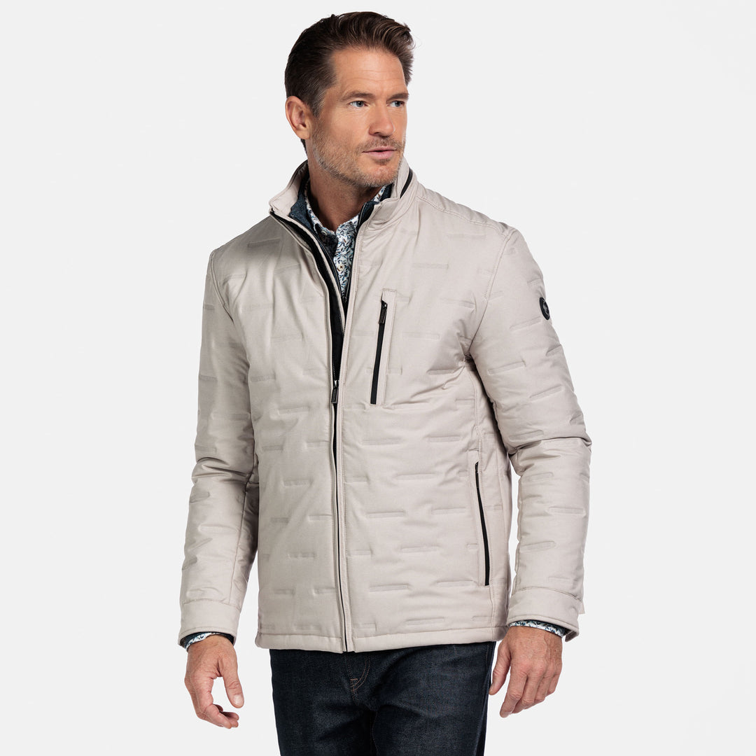 Man wearing a beige quilted jacket on a white background