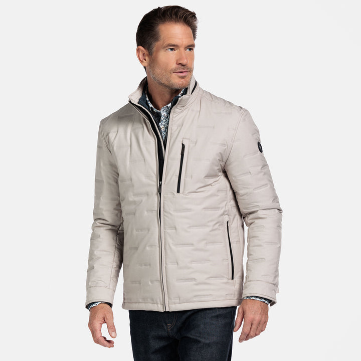 Man wearing a beige quilted jacket on a white background