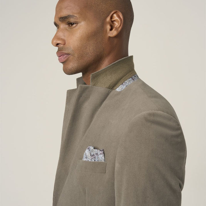 Man wearing a brown suit with a patterned pocket square on a beige background