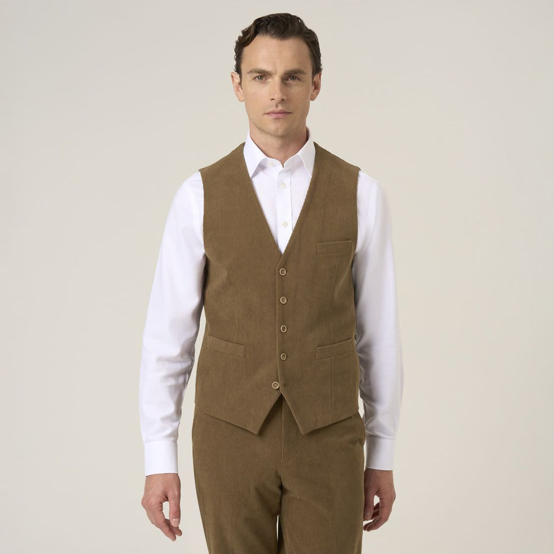Man wearing a brown vest over a white shirt on a plain background