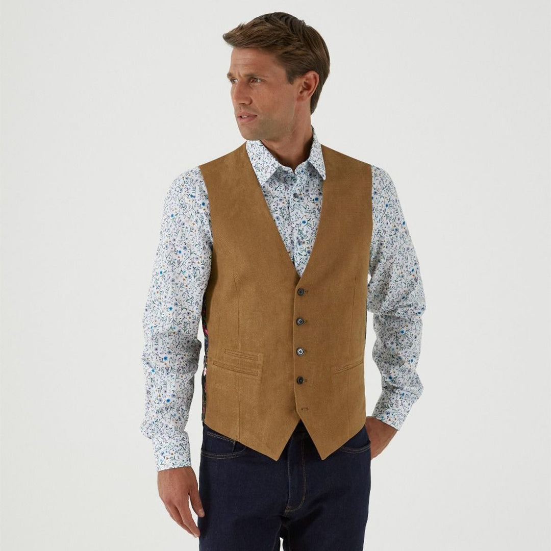 Man wearing a brown vest over a patterned shirt on a white background