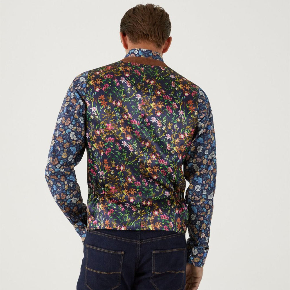 Man wearing a colorful floral patterned shirt on a plain background