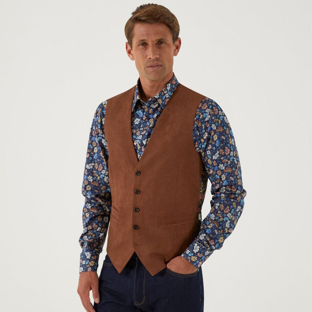 Man wearing a brown vest over a floral shirt on a white background
