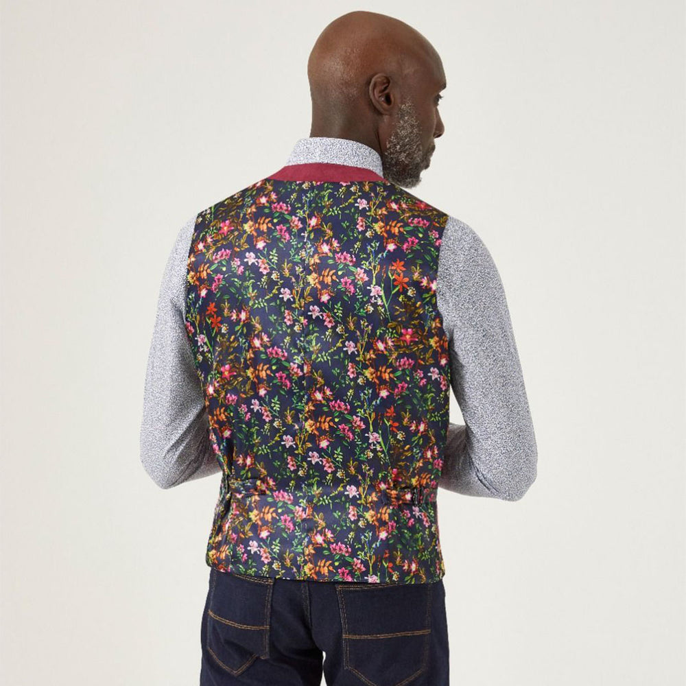 Man wearing a floral patterned vest on a plain background