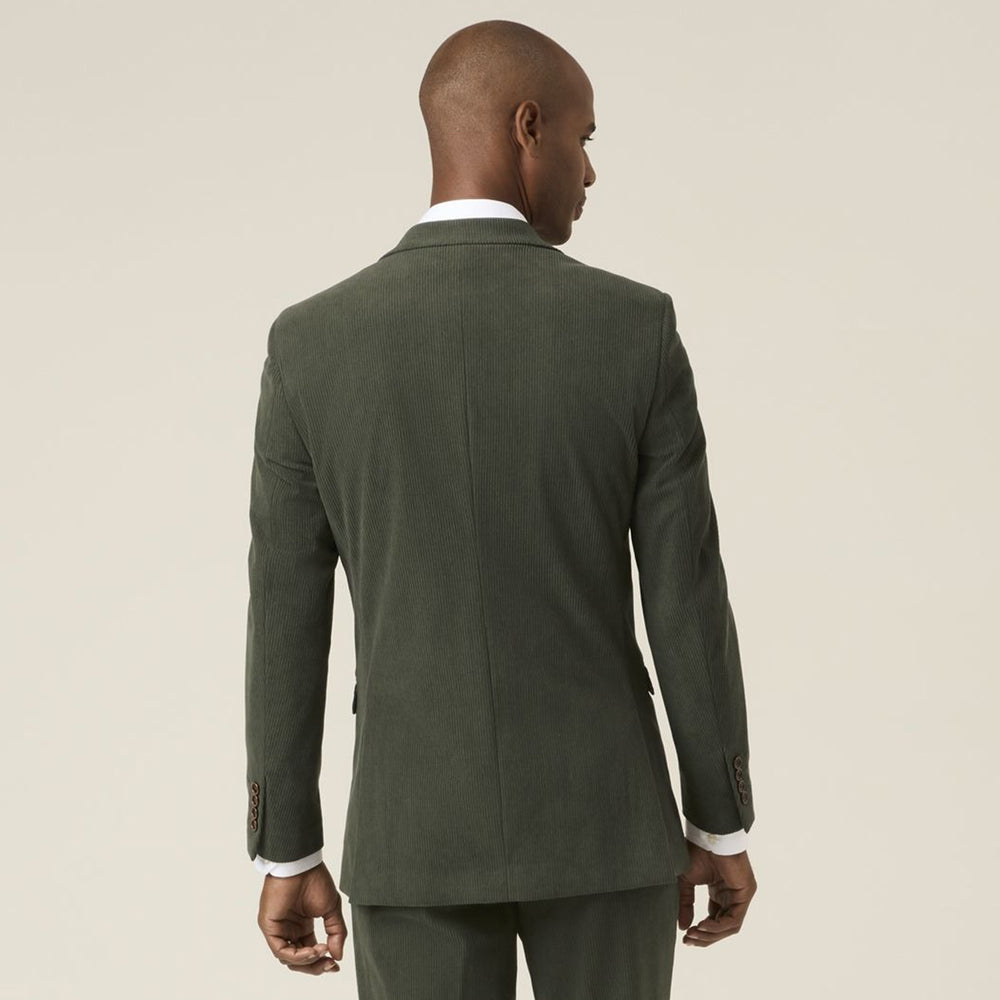Man wearing a green suit jacket on a beige background