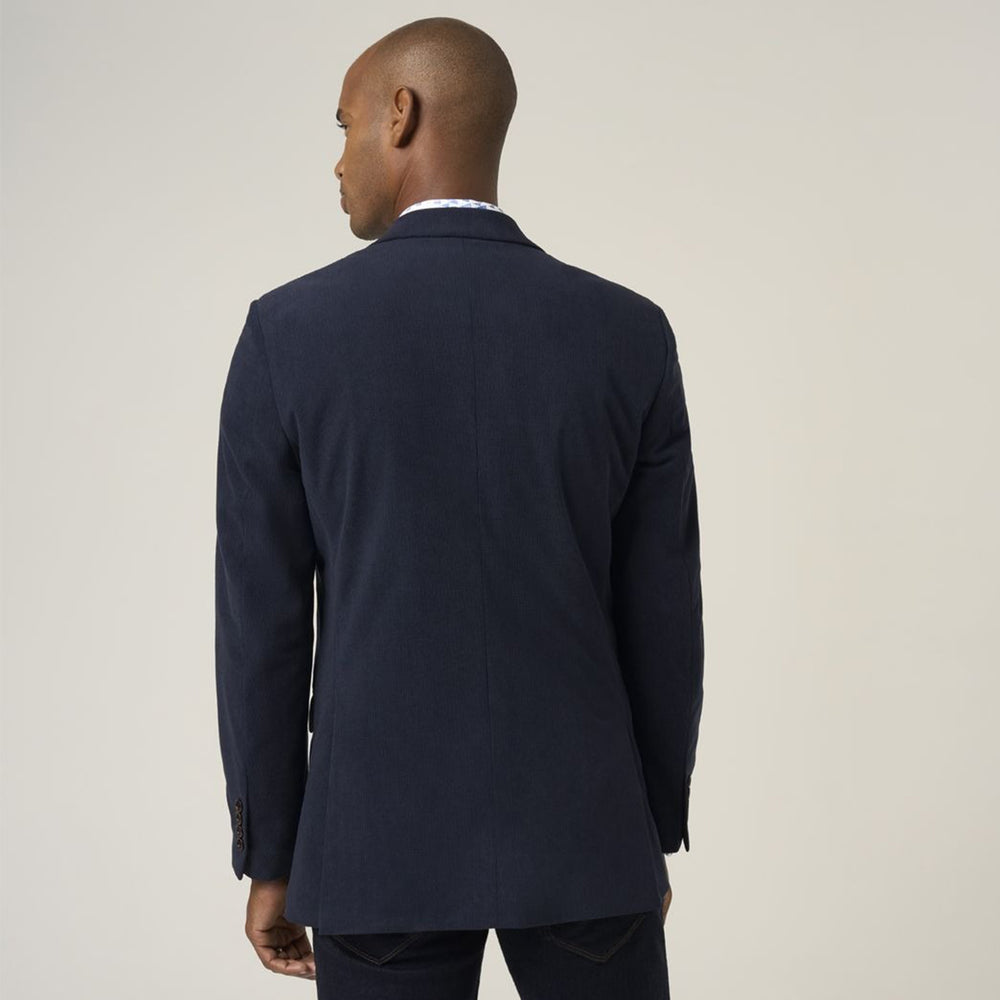 Man wearing a navy suit jacket on a plain background
