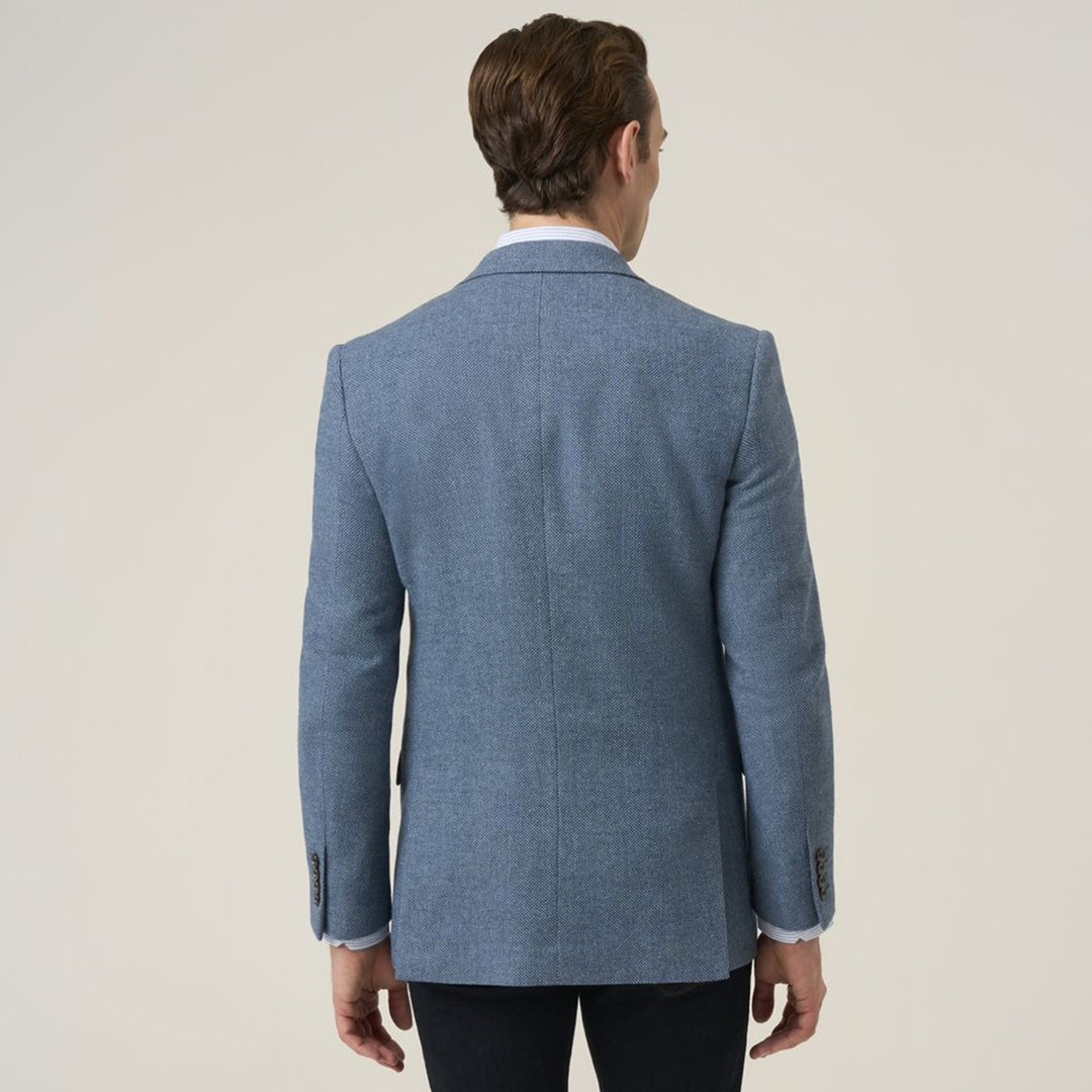 Man wearing a blue blazer from behind on a plain background