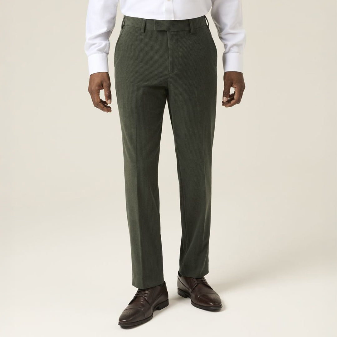Green dress pants worn with a white shirt and brown shoes on a plain background