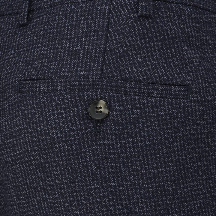 Close-up of a button on a textured navy blue fabric