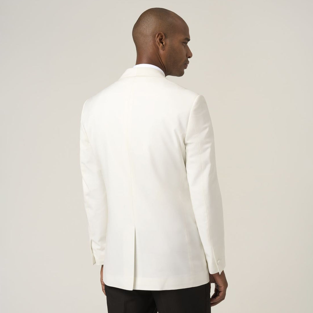 Man wearing a white blazer against a plain background