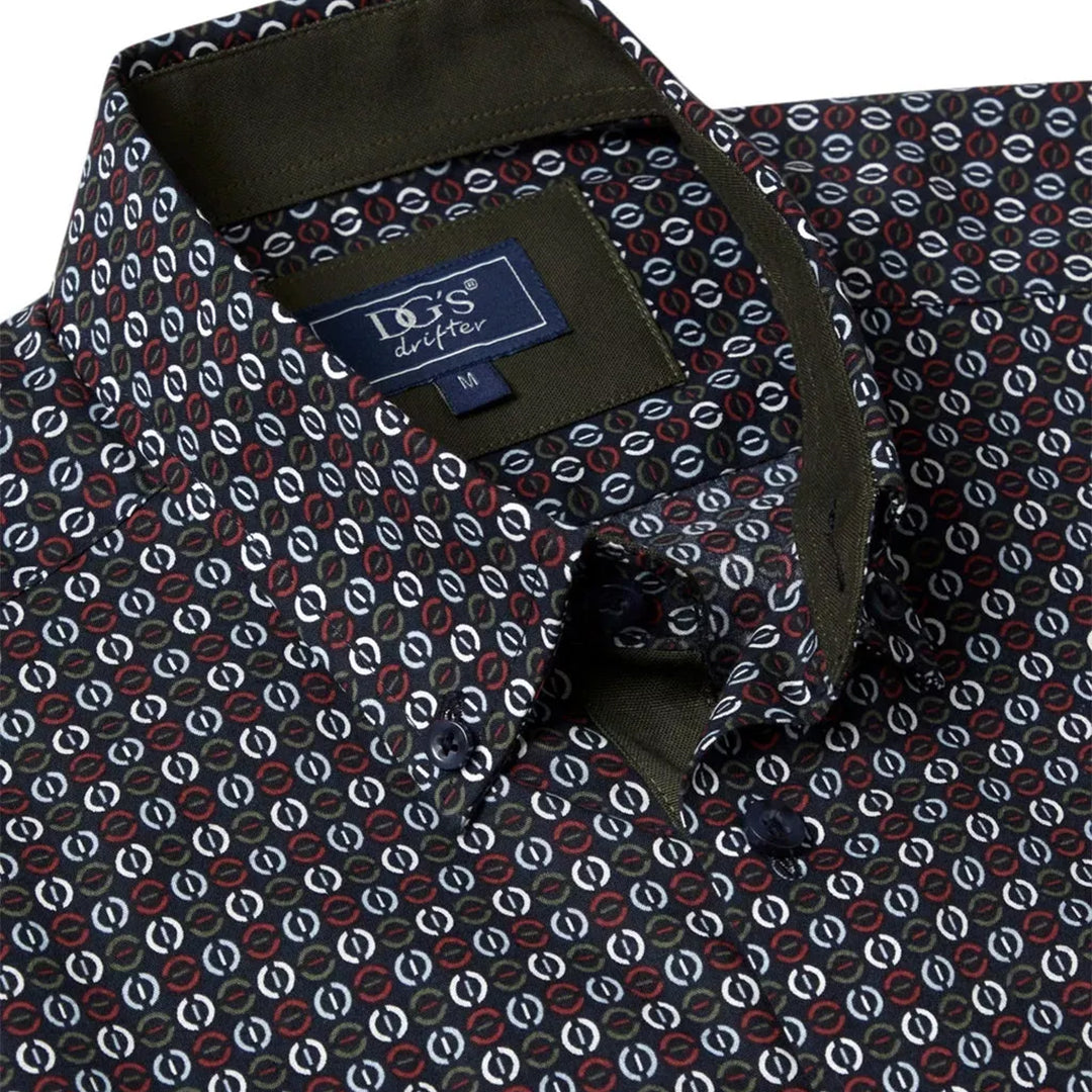 Close-up of a patterned shirt with a brand label, featuring geometric shapes.