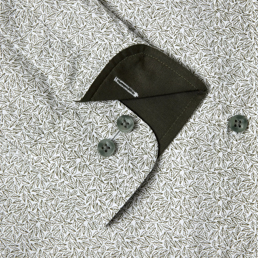 Green shirt with buttons on a patterned fabric background