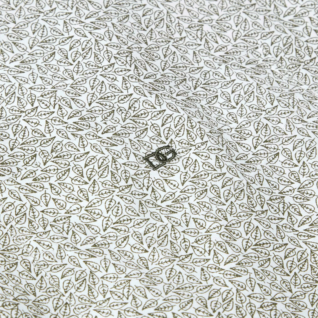 Patterned fabric with a small greenrectangular object on a white background