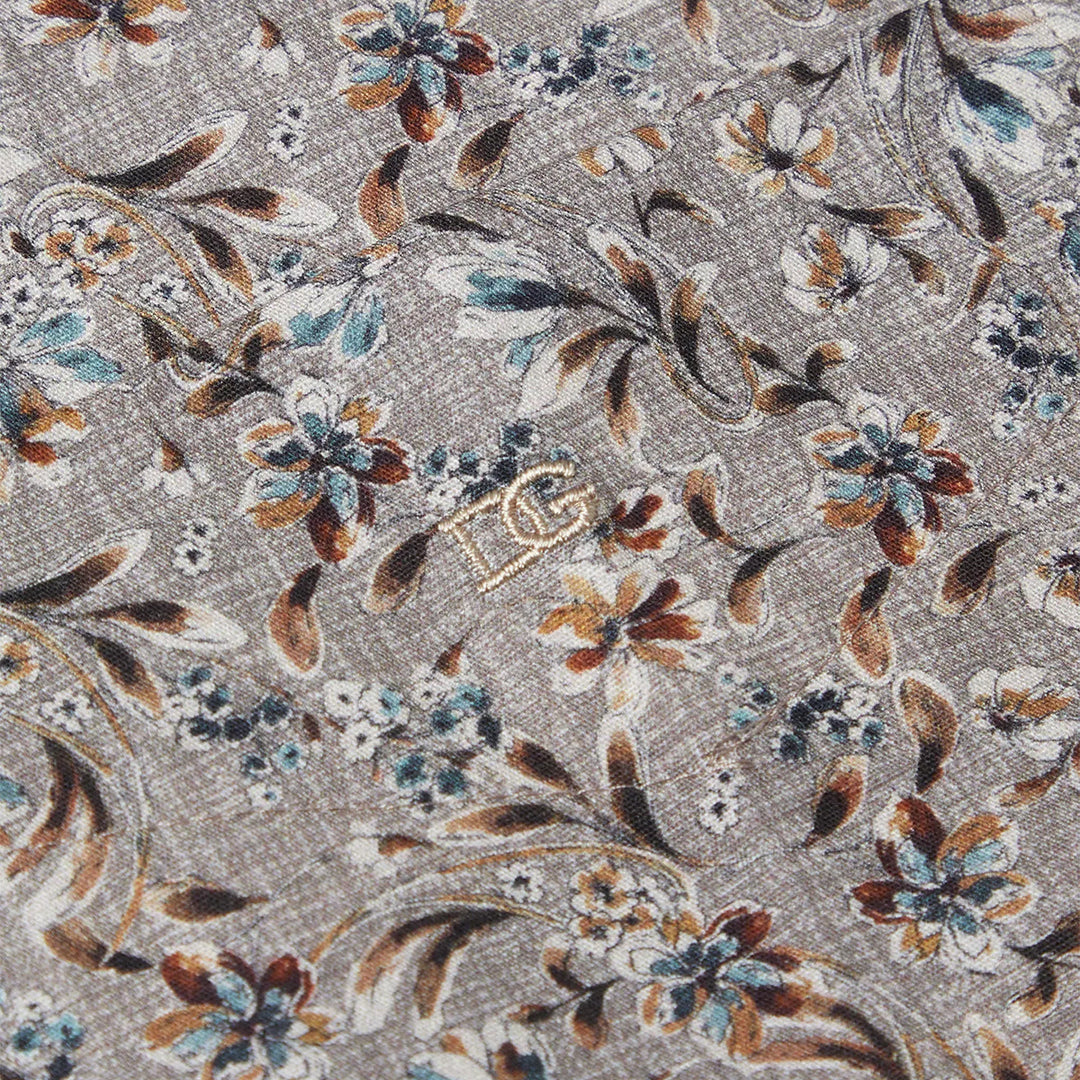 Floral patterned fabric with brown, blue, and white colors on a gray background