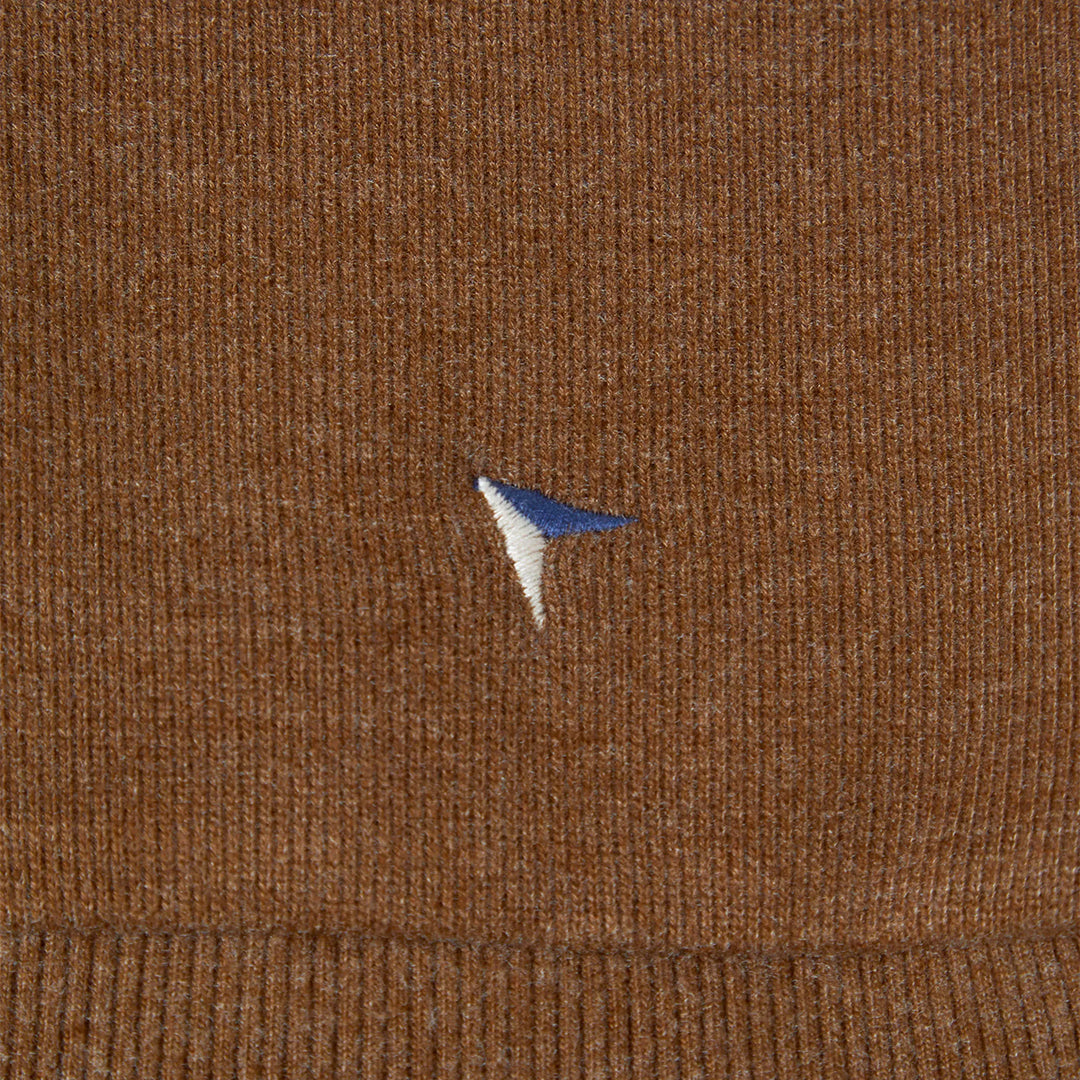 Close-up of brown fabric with a small embroidered logo.