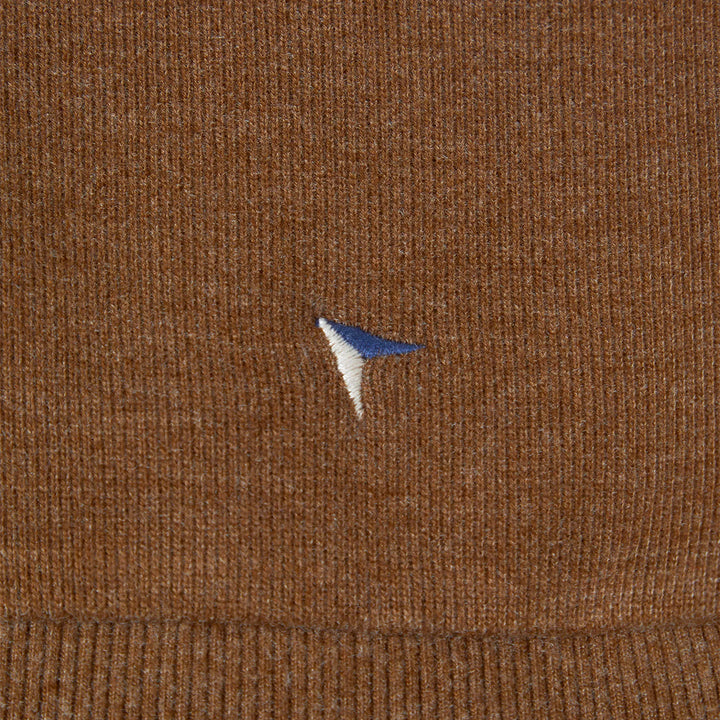 Close-up of brown fabric with a small embroidered logo.