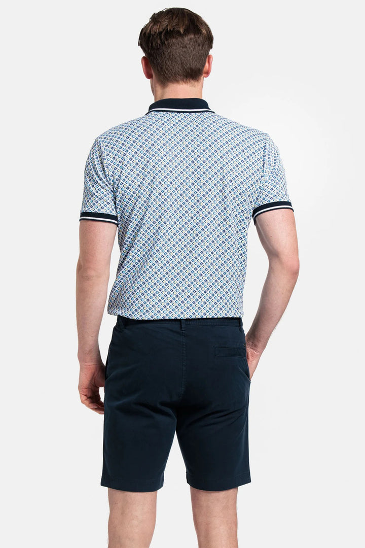Man wearing a patterned blue shirt and dark shorts on a white background
