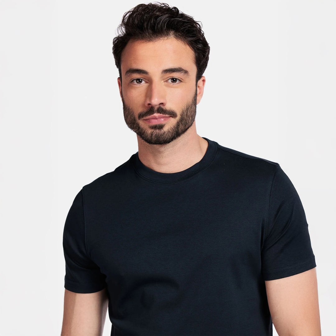 Man wearing a navy t-shirt against a plain background