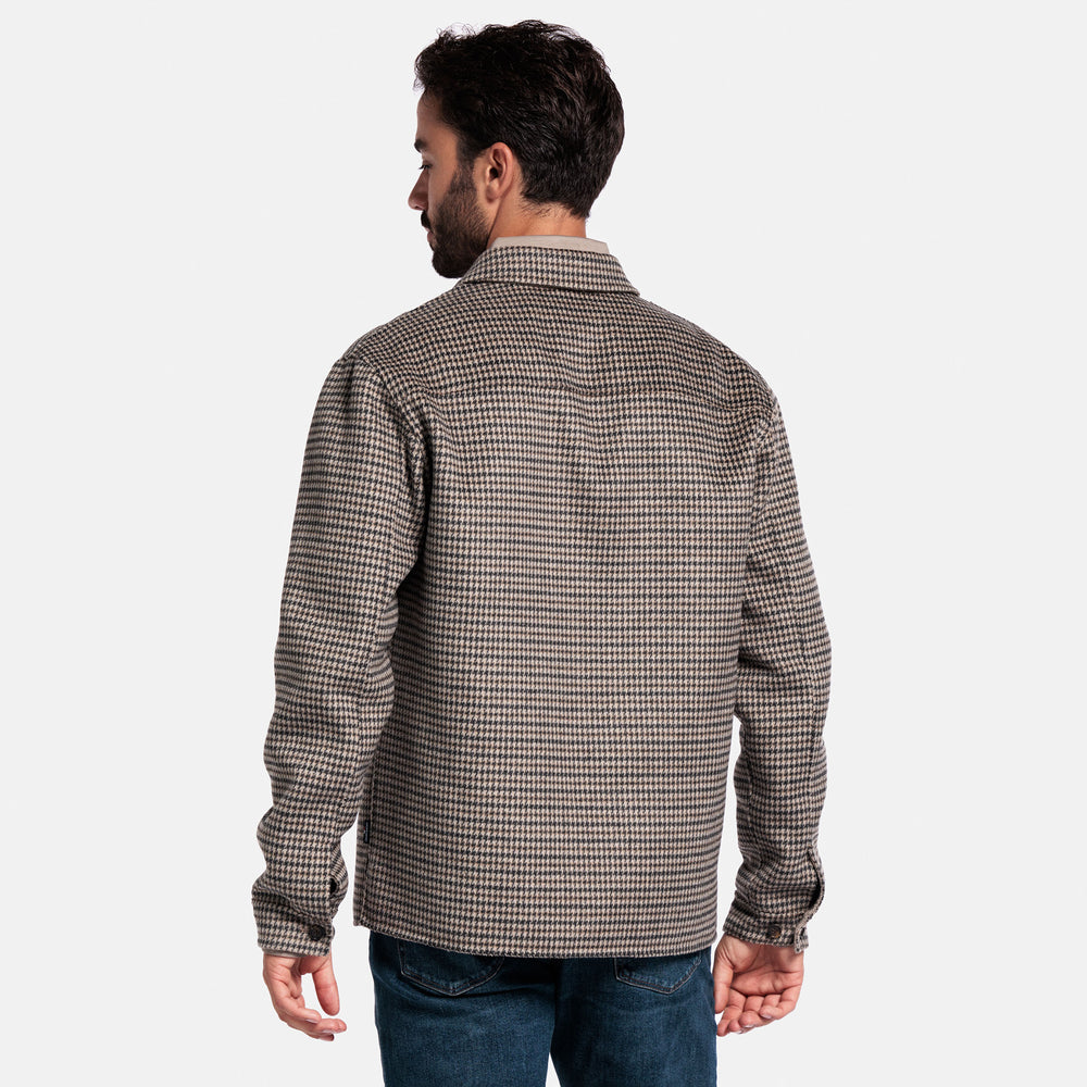 Man wearing a checkered shirt on a plain background