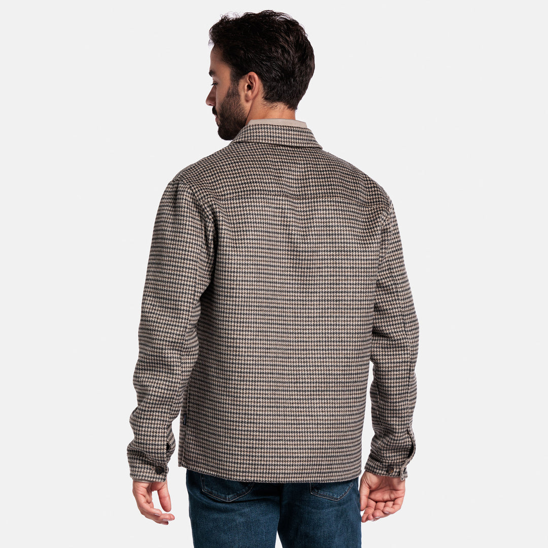 Man wearing a checkered shirt on a plain background