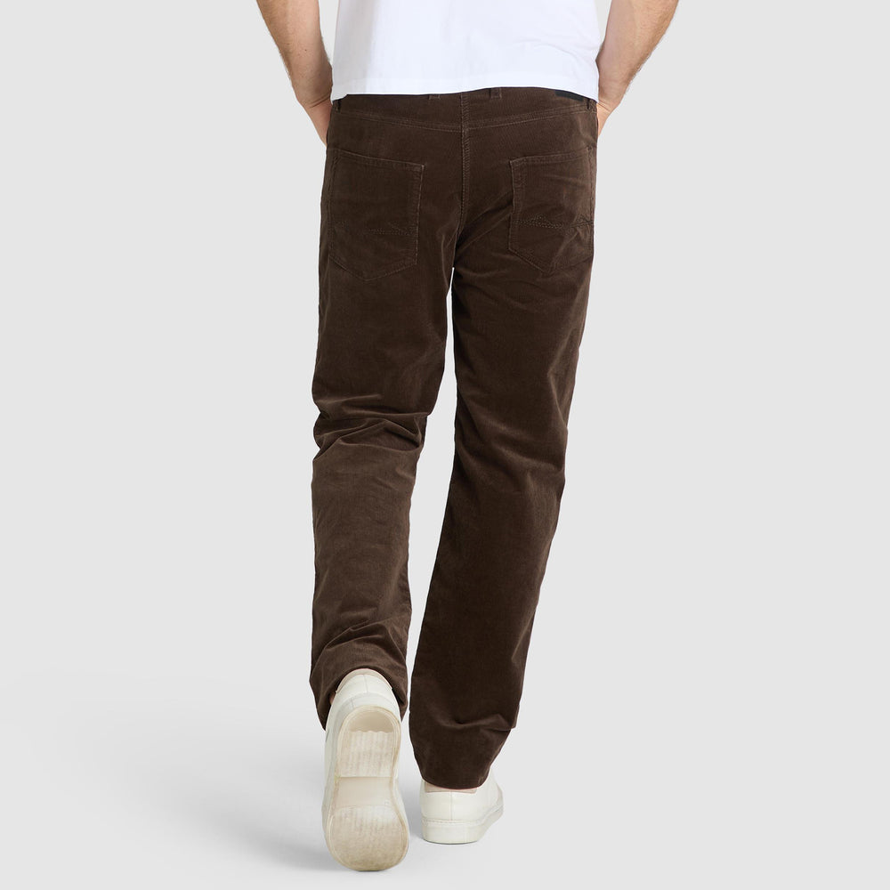 Person wearing brown corduroy pants on a white background