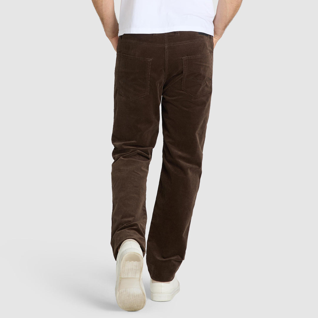 Person wearing brown corduroy pants on a white background