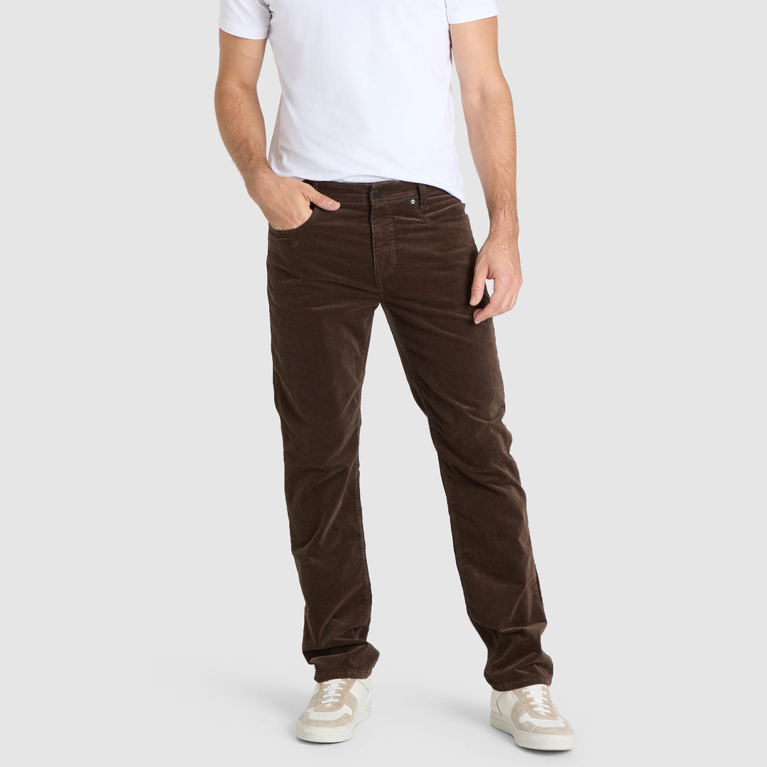 Person wearing brown corduroy pants on a white background