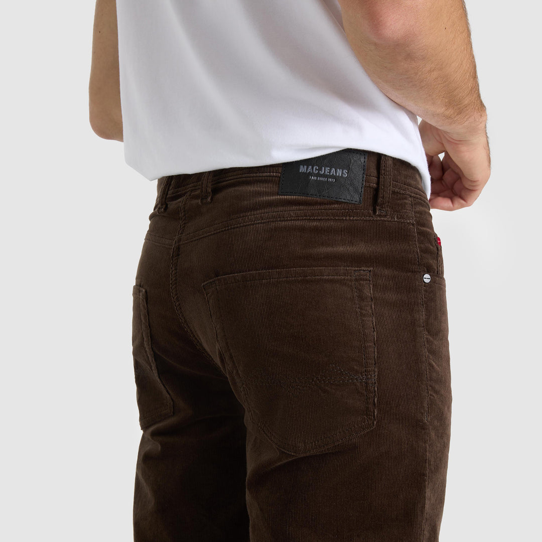 Brown jeans with a visible brand label on a white background