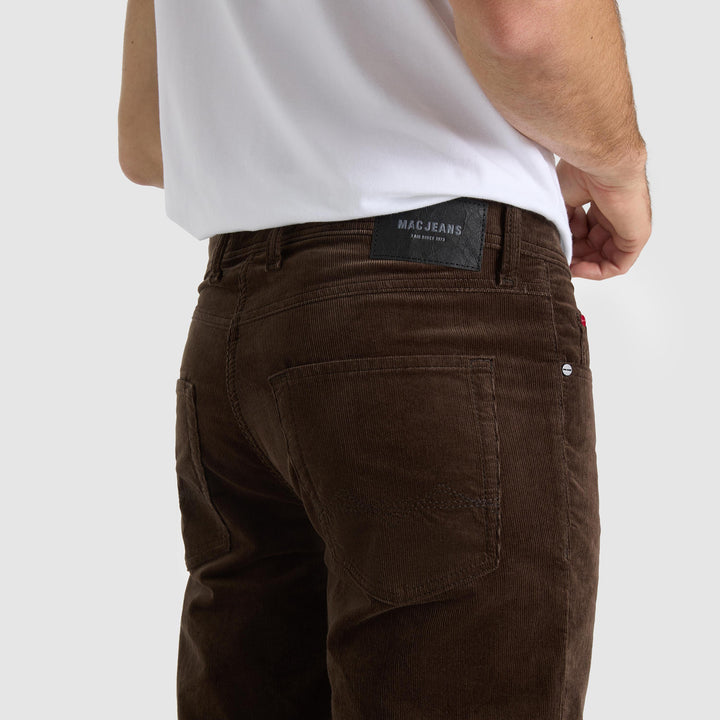 Brown jeans with a visible brand label on a white background