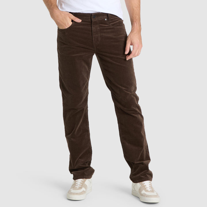 Brown corduroy pants worn by a person on a white background