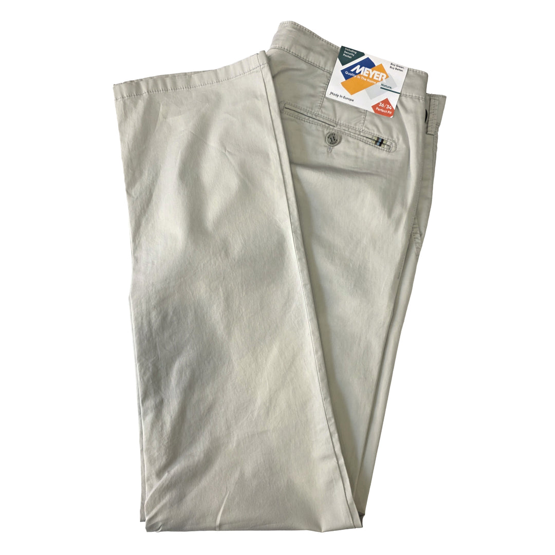 Folded light gray pants with a tag on a white background