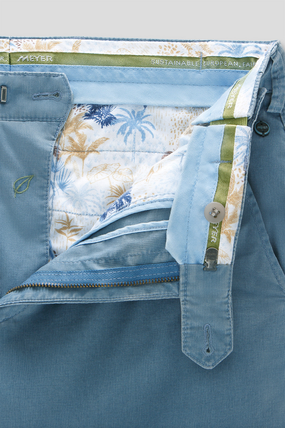 Close-up of a blue garment with floral lining and brand label.