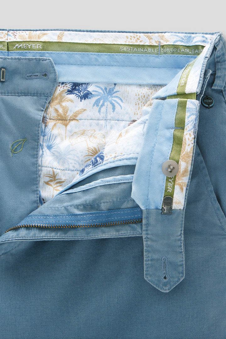 Close-up of a blue garment with floral lining and brand label.