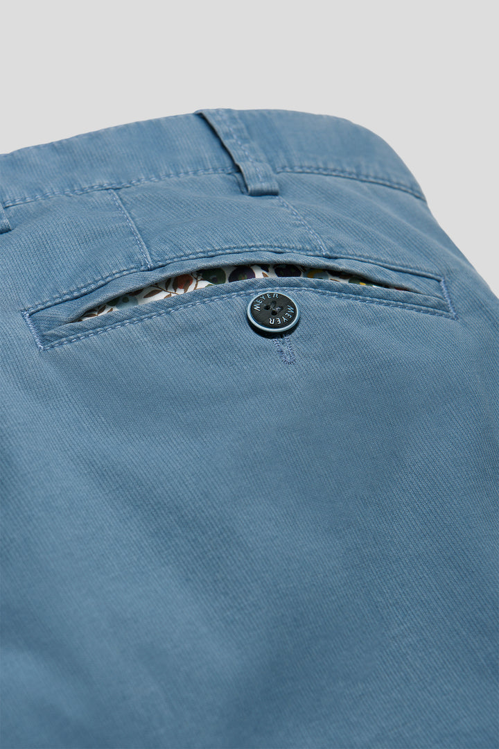 Close-up of blue pants with a button on a gray background