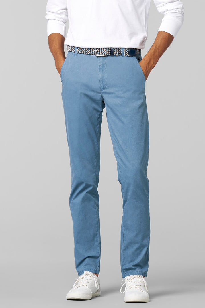 Person wearing light blue pants and a white shirt on a gray background