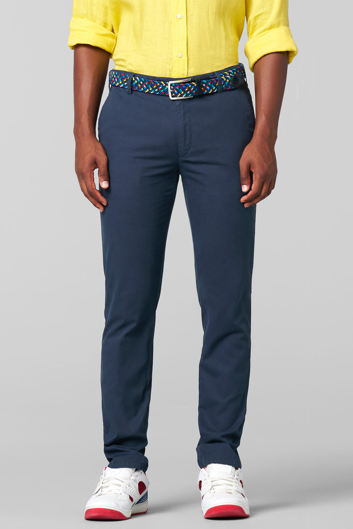Person wearing navy pants with a colorful belt on a gray background