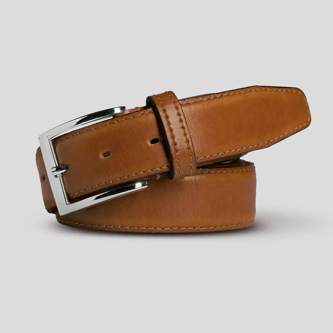 Brown leather belt with silver buckle on a light gray background
