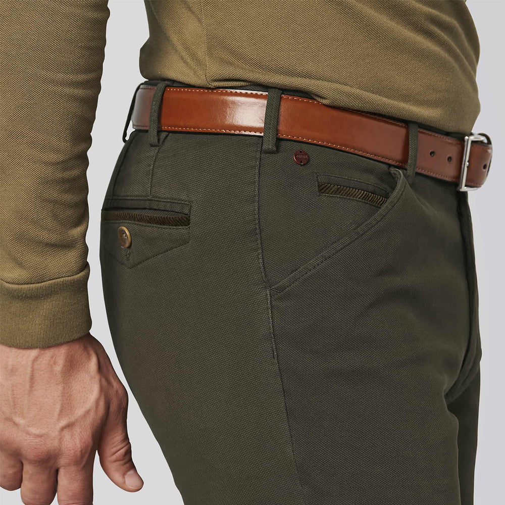 Person wearing green pants with a brown belt on a light gray background