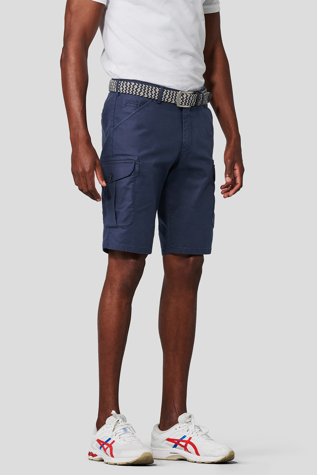 Person wearing navy cargo shorts on a white background
