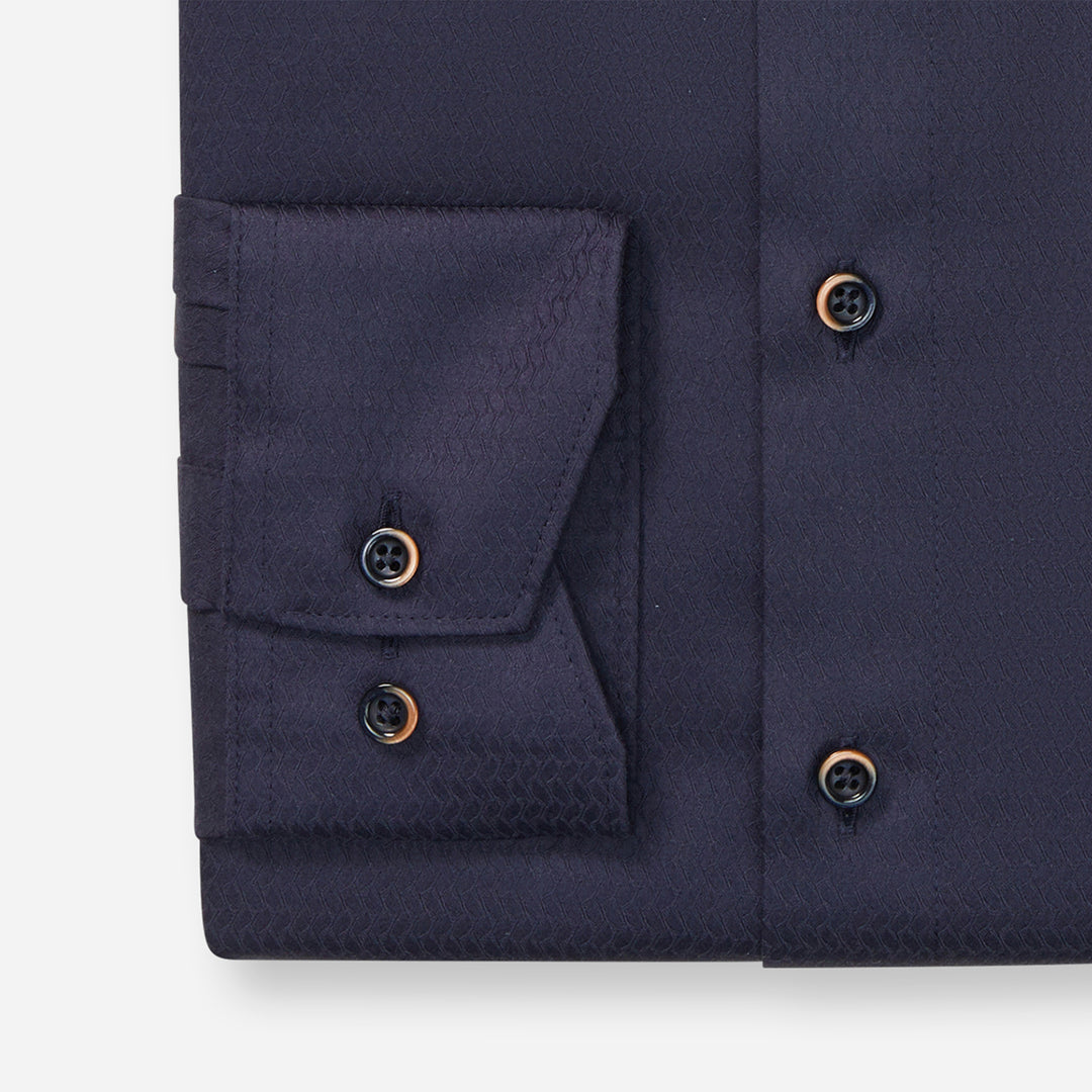 Close-up of a navy blue shirt with button details on a white background