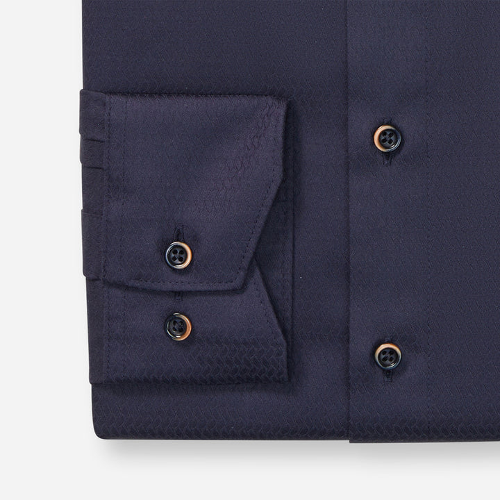 Close-up of a navy blue shirt with button details on a white background